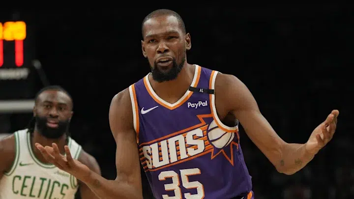Kevin Durant in Phoenix Suns Jersey Kevin Durant wearing a Phoenix Suns jersey during a basketball game, gesturing towards the referee.