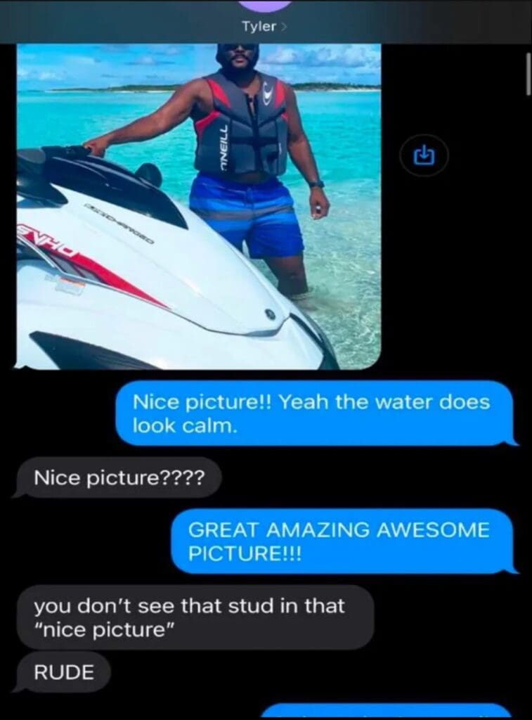 Individual wearing a life jacket standing next to a jet ski in calm water.