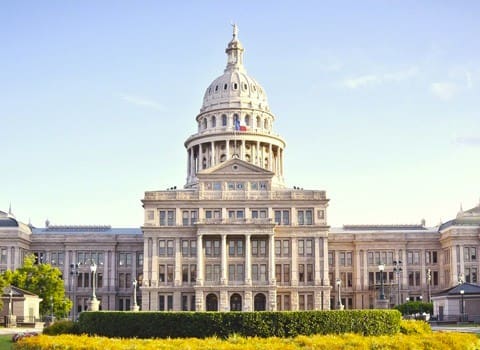 The Texas State Capitol building featuring a dome and classical architectural design.