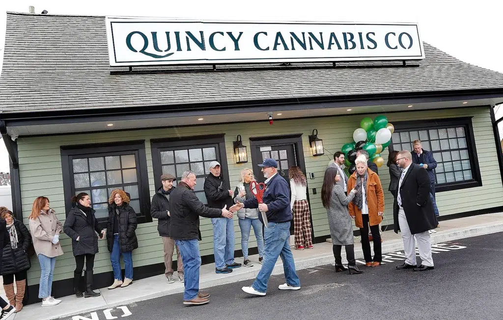 Exterior view of Quincy Cannabis Company with people gathered outside the entrance.