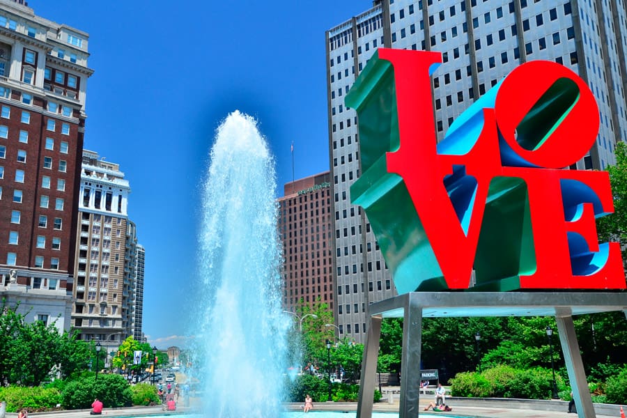 Colorful LOVE sculpture in Love Park with a fountain in the background.
