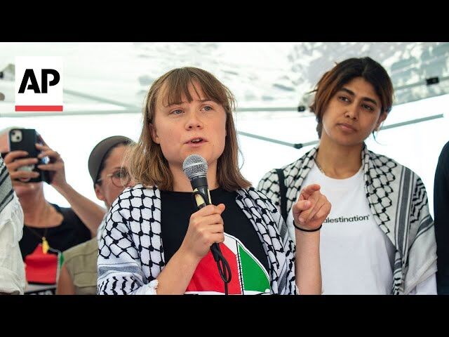 Greta Thunberg speaking into a microphone with Rima Hassan standing beside her at an event.