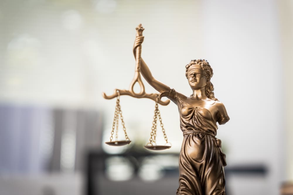 Bronze statue of Lady Justice holding scales and wearing a blindfold.