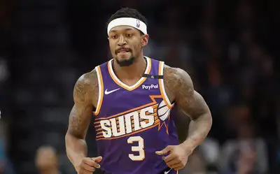 Basketball player wearing a purple Phoenix Suns jersey with the number 3 and a headband during a game.