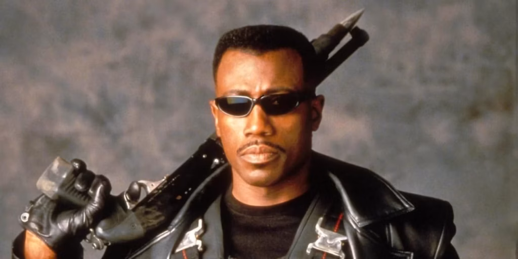 Wesley Snipes wearing sunglasses and holding a blade in a leather outfit.