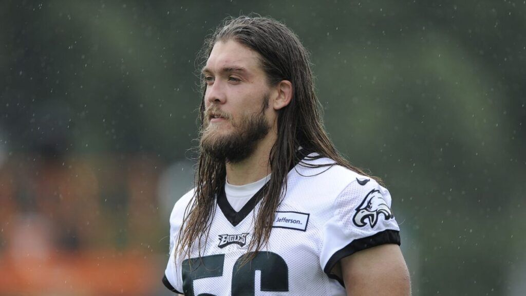 Football player wearing a Philadelphia Eagles jersey with the number 56 during practice.