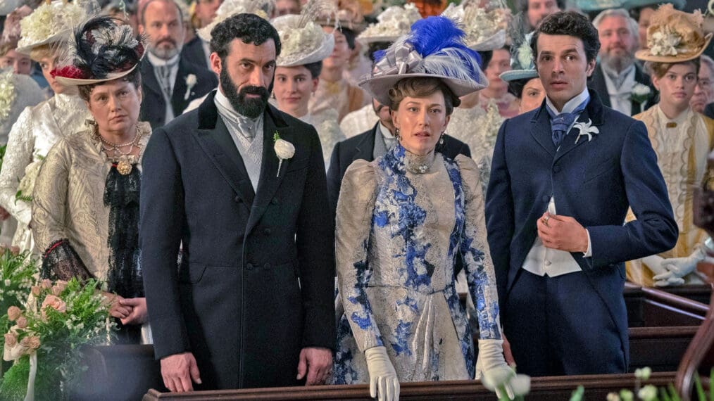 A scene from The Gilded Age featuring Carrie Coon in period attire at a formal event.