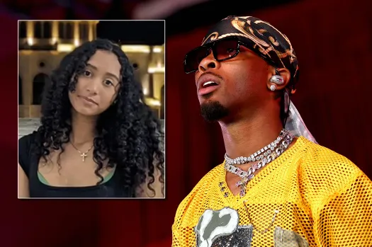 A young woman with curly hair wearing a black top and a cross necklace, looking directly at the camera.