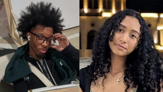 A young man with glasses and curly hair sitting beside a young woman with curly hair and a cross necklace.