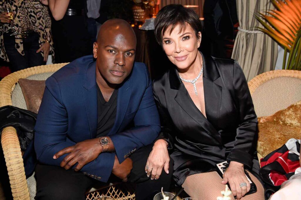 Kris Jenner sitting next to a man in formal attire at a social event.