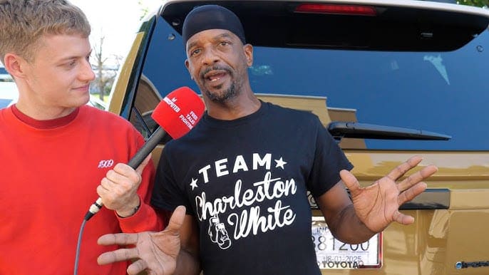 Charleston White wearing a 'Team Charleston White' t-shirt while speaking to an interviewer.